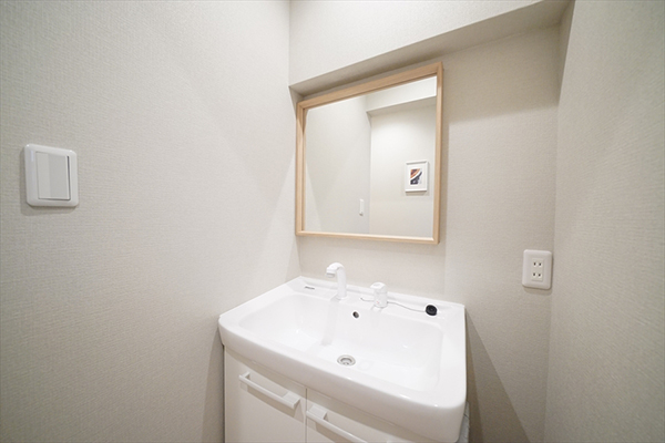 The shared wash basin is convenient with a large mirror